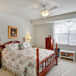 A cozy and well-decorated bedroom featuring a comfortable bed, elegant furnishings, and natural light.