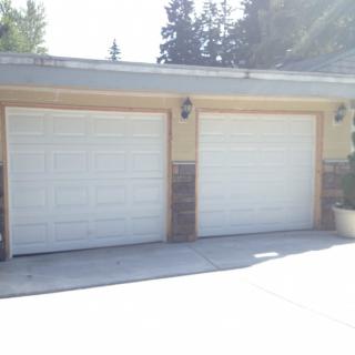 A residential building with two white garage doors.