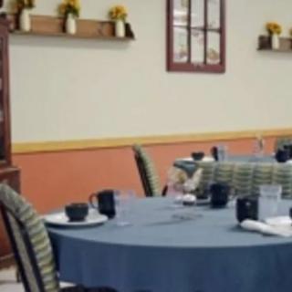 A neatly arranged restaurant dining area with tables set for guests.