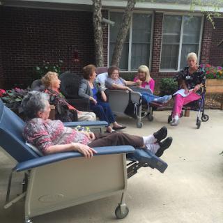 Elderly residents enjoying a sunny afternoon together at a care facility.