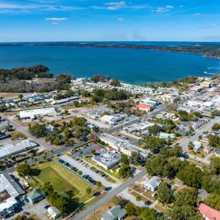 A scenic aerial view of a coastal town nestled by the water, showcasing a blend of natural beauty and urban development.