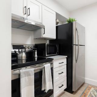 A modern kitchen with stainless steel appliances and white cabinets.