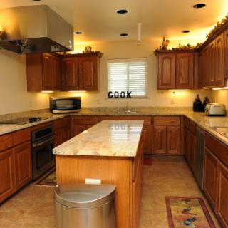 A spacious and modern kitchen featuring wooden cabinets, a large countertop, and various appliances.