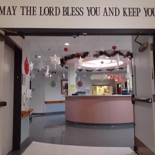 A festive entrance with holiday decorations and a blessing quote above the doorway.