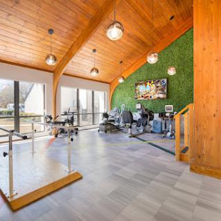 A contemporary office space featuring a green wall and wooden beams, designed for an inviting work environment.