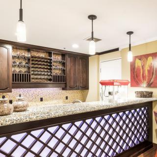 A stylish home bar with modern lighting and a wine rack.