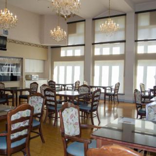 A bright dining area with elegant chandeliers and large windows.