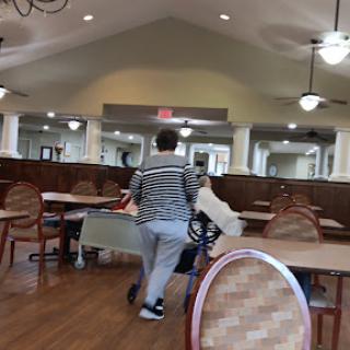 A person walking through a dining area, carrying items in a casual setting.