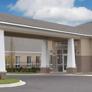 A modern building entrance with large columns and a clear blue sky.