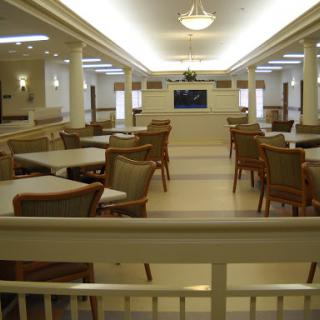 A spacious dining area with modern furniture, featuring bright lighting and a welcoming atmosphere.