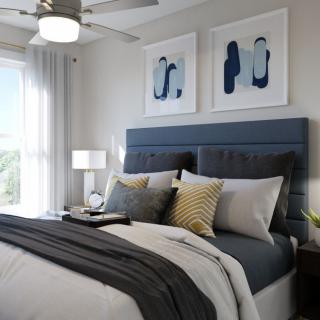 A modern and stylish bedroom featuring a plush bed with layered bedding, abstract artwork, and elegant decor.
