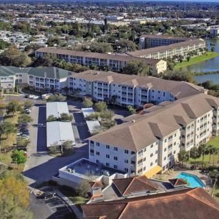 Aerial view of a suburban apartment complex surrounded by other residential buildings and scenic landscape.