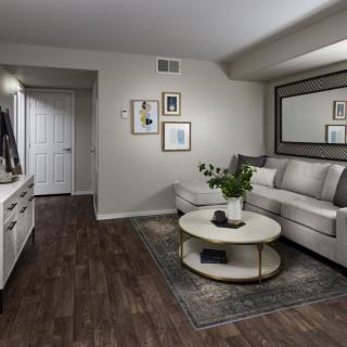 A modern living room with a white sofa, stylish coffee table, and wood flooring complementing the decor.