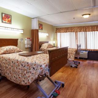 A hospital room with two patient beds and medical equipment.