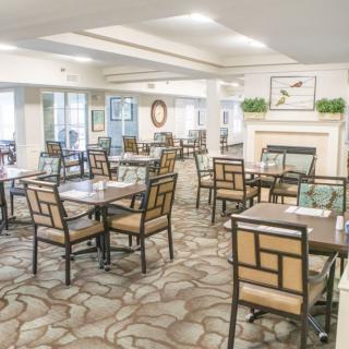 A bright and spacious dining room with neatly arranged tables and chairs, featuring a cozy and inviting decor.