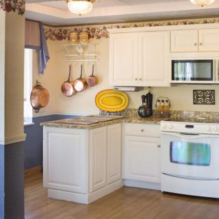 A cozy kitchen with white cabinets and modern appliances.