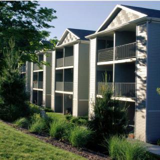 A modern apartment building with balconies and well-maintained landscaping.