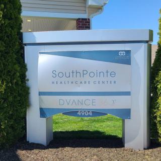 A sign for SouthPointe Healthcare Center with clear skies in the background.