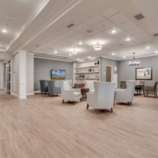 A modern lounge area with comfortable seating, a television, and elegant lighting.