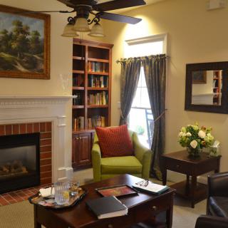 A cozy living room with a fireplace, bookshelves, and comfortable seating.