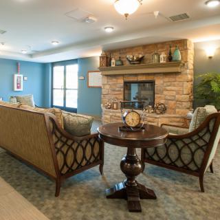 A cozy living room with elegant furniture and a stone fireplace.