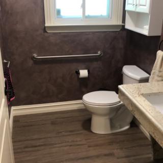 A clean bathroom with a toilet, sink, and window.