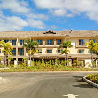 A tropical hotel with palm trees and a clear blue sky.