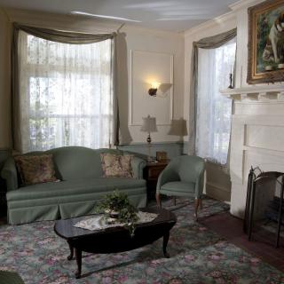 A traditional living room with a green sofa, coffee table, and fireplace.