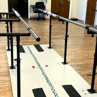 A set of parallel bars used for physical therapy and rehabilitation exercises in a facility.