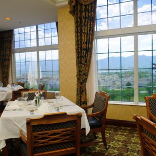 A cozy restaurant dining area with large windows offering a scenic mountain view.