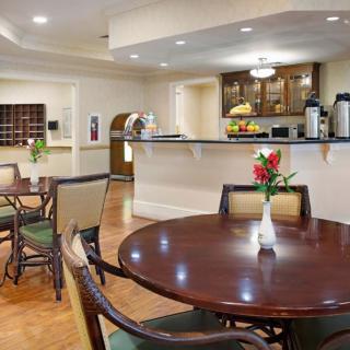 A cozy indoor dining area with tables and chairs, featuring a counter and coffee station.