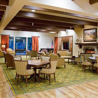 A cozy and well-decorated lounge area with comfortable seating, a fireplace, and large windows.