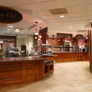 A spacious cafeteria with wooden counters and a variety of serving areas.