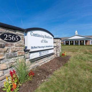 A healthcare facility with a prominent entrance sign and well-maintained landscaping.