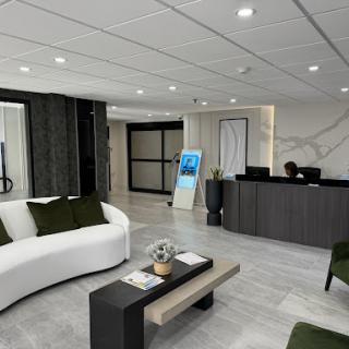 A modern office lobby featuring a stylish white sofa and a sleek reception desk.