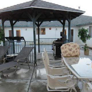 A cozy outdoor space featuring a gazebo, grill, and comfortable seating arrangements.