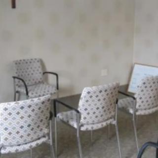 A small waiting room with patterned chairs arranged around a table.