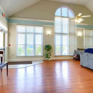 Spacious living room with high ceilings and large windows allowing natural light to flood the space.