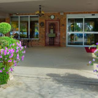 A welcoming entrance adorned with colorful flowers and lush greenery.