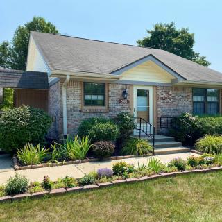 A charming suburban brick house with well-maintained landscaping.
