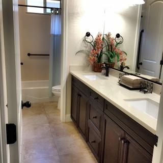 A modern bathroom featuring a double sink vanity and a spacious shower area.