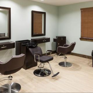 A modern hair salon with styling chairs and mirrors.