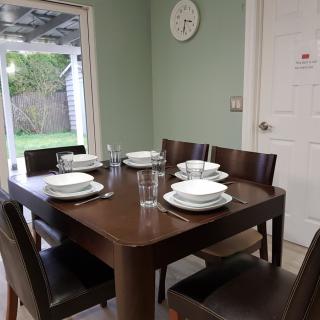 A neatly set dining table with plates and glasses in a cozy dining room.
