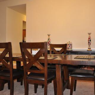 A dining room with a wooden table and chairs, adorned with decorative items.
