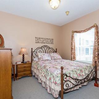 A cozy bedroom with floral patterns and wooden furniture.