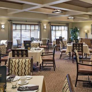 An elegant dining area with neatly arranged tables and chairs, featuring soft lighting and tasteful decor.