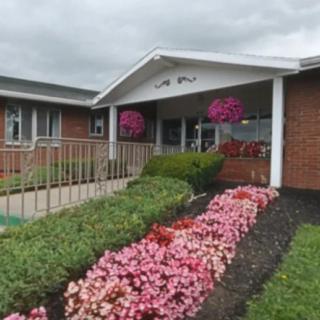 A building entrance surrounded by vibrant flowers and landscaped garden beds.