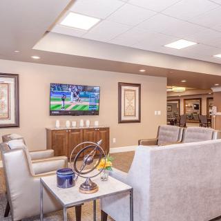 A modern living room with a comfortable seating area and a television on the wall.