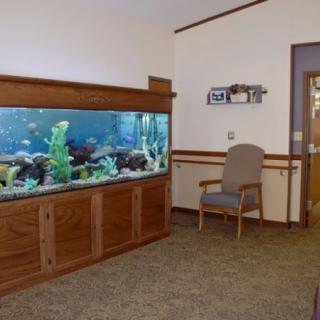 A waiting room with a large aquarium and a comfortable chair.