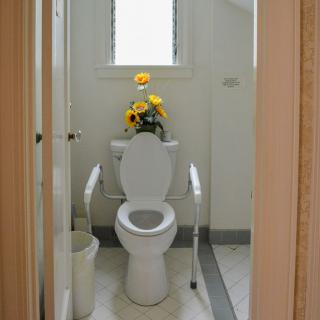 A small bathroom with a toilet and sunflower decoration.